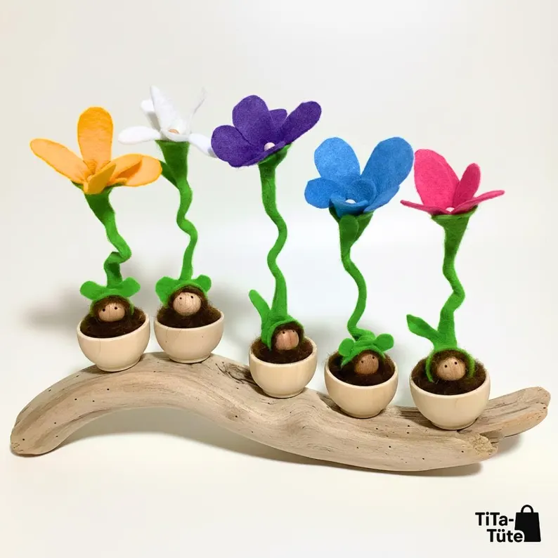 Fünf Wurzel-Wichtel als farbenfrohe Blumenkinder in kleinen Holztöpfen